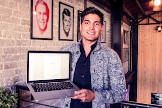 man holding MacBook Pro