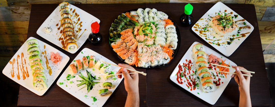 assorted sushi on plates on table,