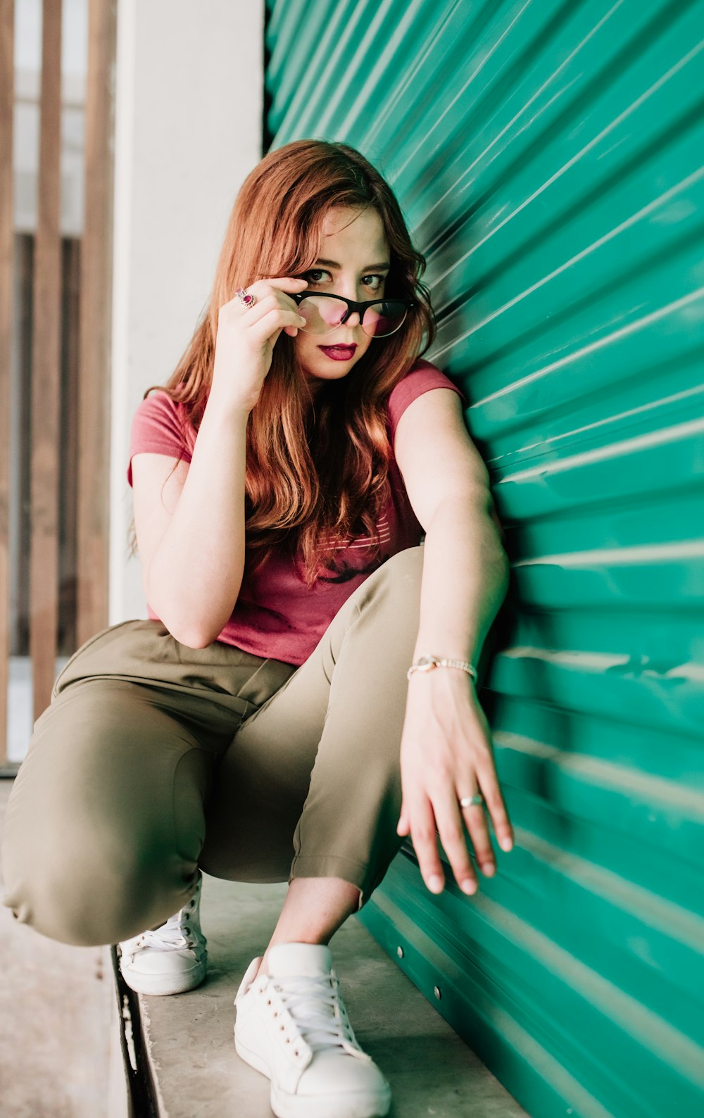 woman wearing brown pants holding eyeglasses