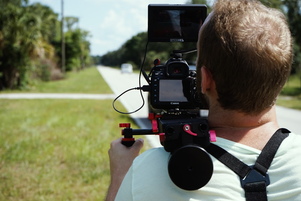 man in white shirt carrying camera with stabilizer