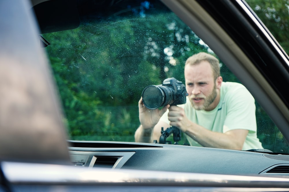 a man taking a picture of himself in a car mirror