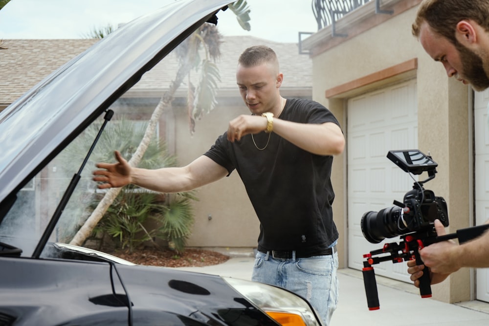 man taking photo of car engine bay