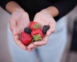 A close-up of hands holding fresh fruits and vegetables.