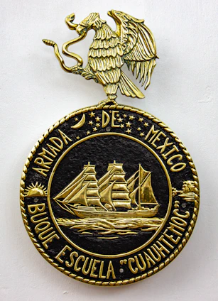 Historic photo of Escuela Naval ARC cadets training on deck with the Colombian flag waving.