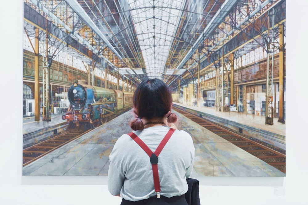 woman looking at train on station painting
