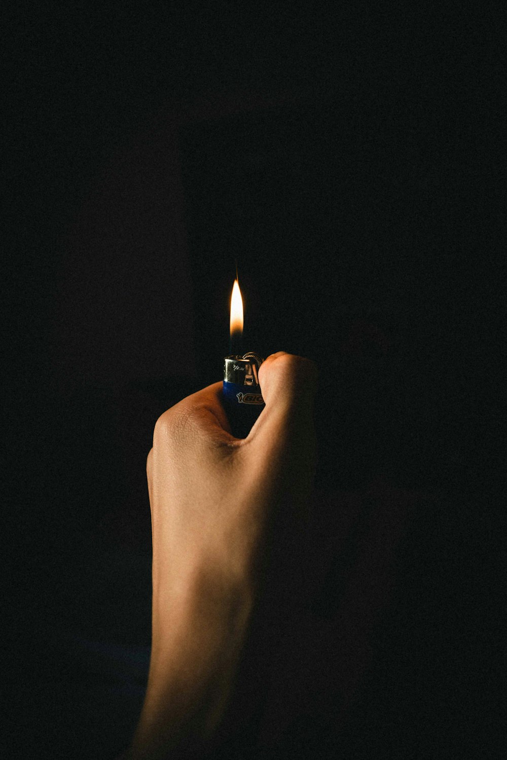 person lighting lighter on black background