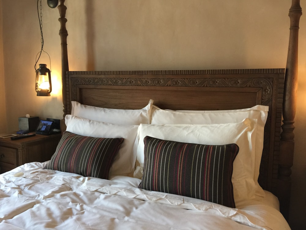 six white and black pillows on bed and black bedside lantern