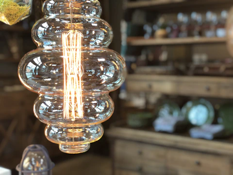 A custom decorative light fixture glowing warmly in a boutique setting.