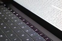 Close-up of hands typing code on a glowing laptop keyboard.