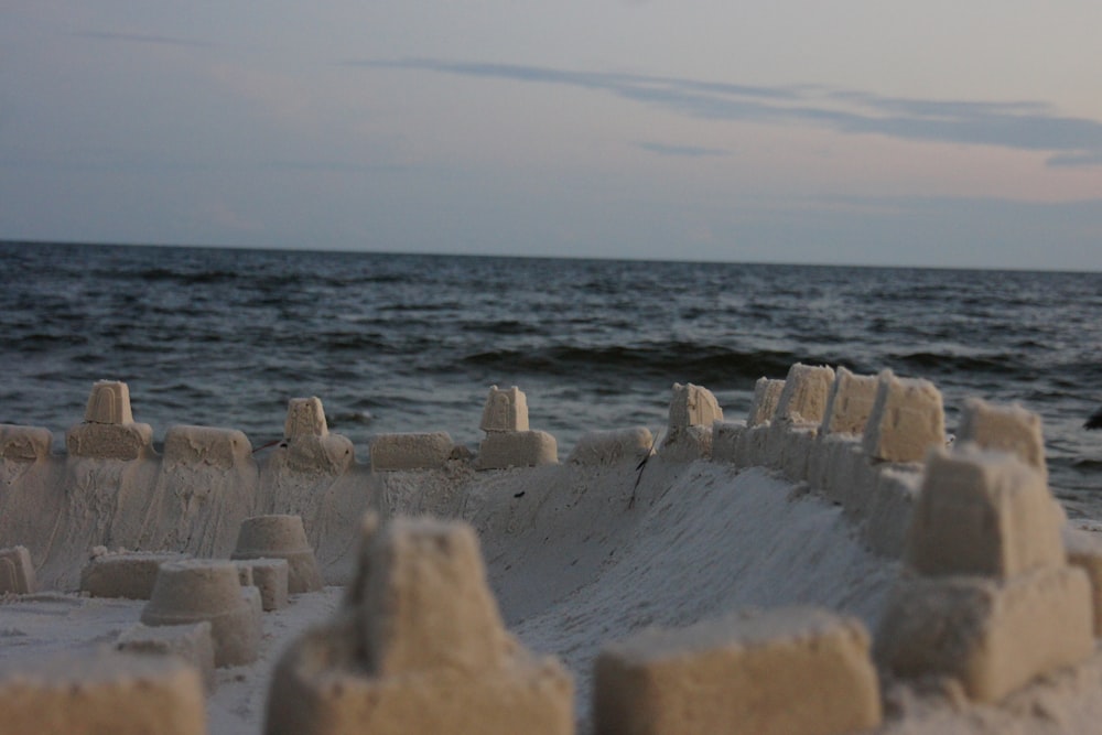 a sand castle sitting on top of a beach next to the ocean