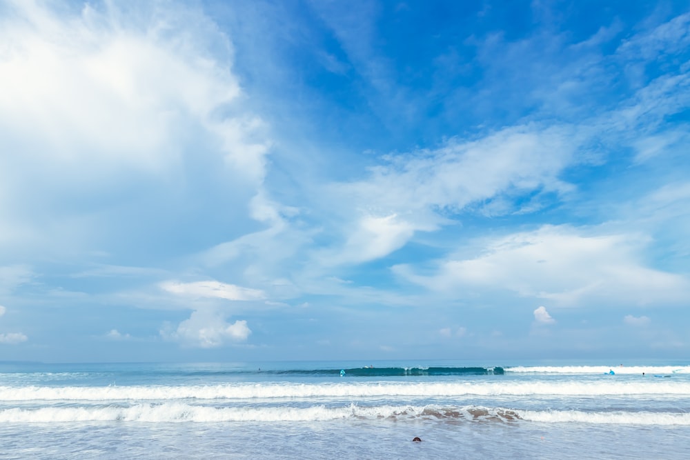 a person walking on the beach with a surfboard