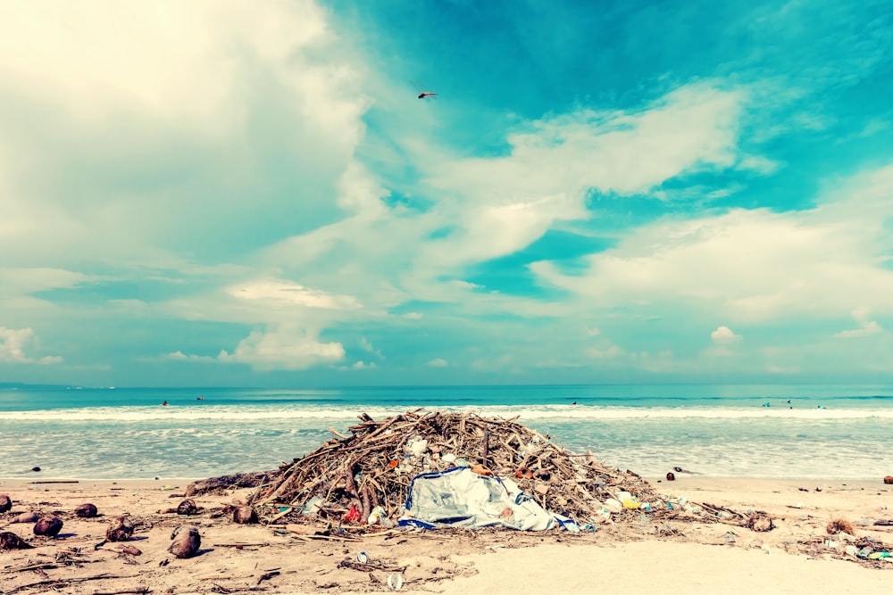 a pile of trash sitting on top of a sandy beach