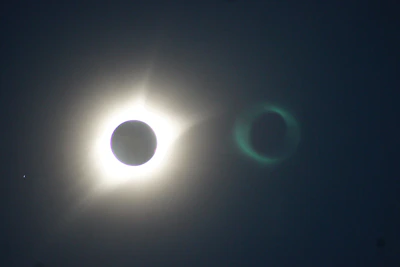 Close-up of solar eclipse glasses with a glowing eclipse reflection on the lenses