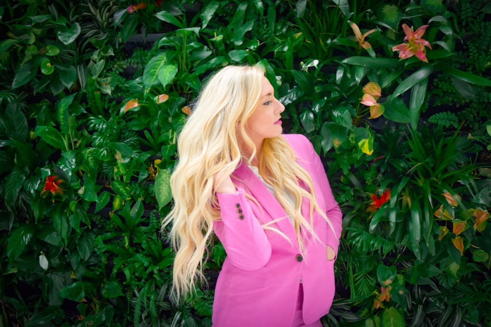 a blonde woman with long hair standing in front of a green wall