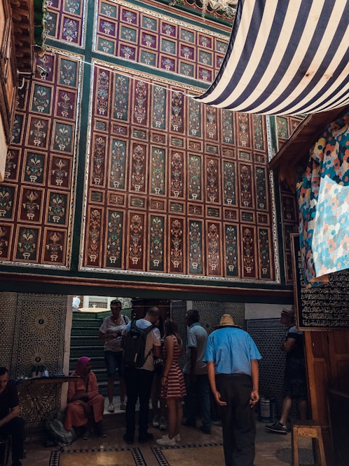A joyful group of Indian travelers sharing a home-cooked meal with their host in a cozy living room filled with traditional decor.