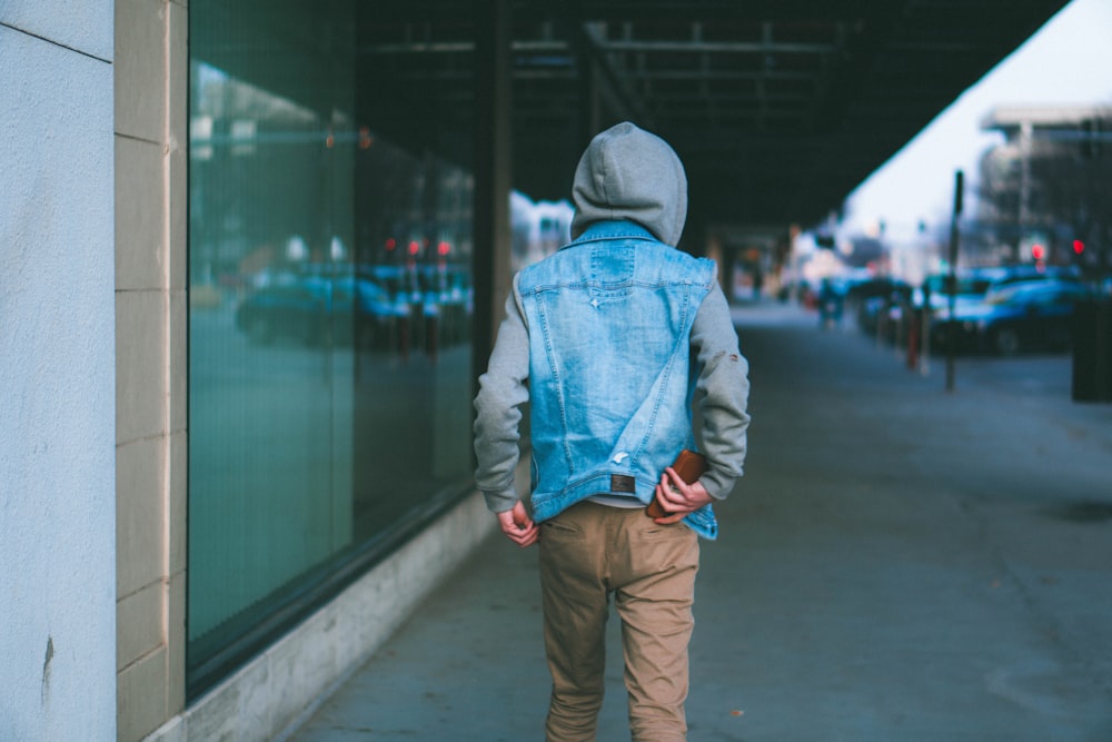 person in gray and blue hoodie and brown pants