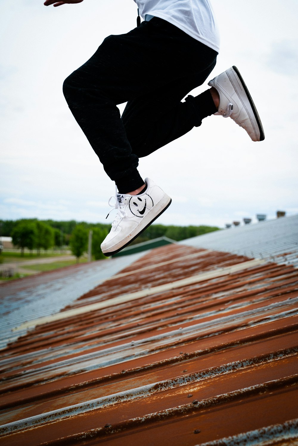 person jumping in roof during daytime