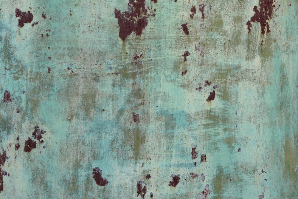 a rusted metal surface with a green pattered surface