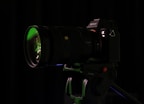 a camera with a green lens on a tripod