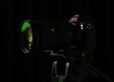 a camera with a green lens on a tripod