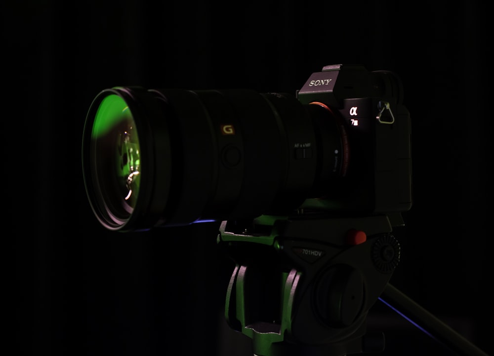 uma câmera com uma lente verde em um tripé