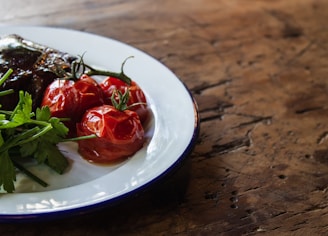 A rustic wooden table adorned with fresh tomatoes and herbs.