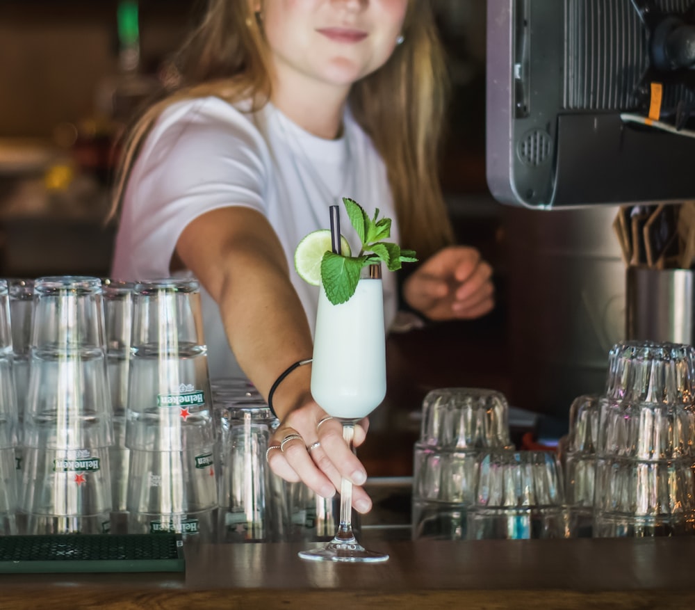 a woman is making a drink at a bar