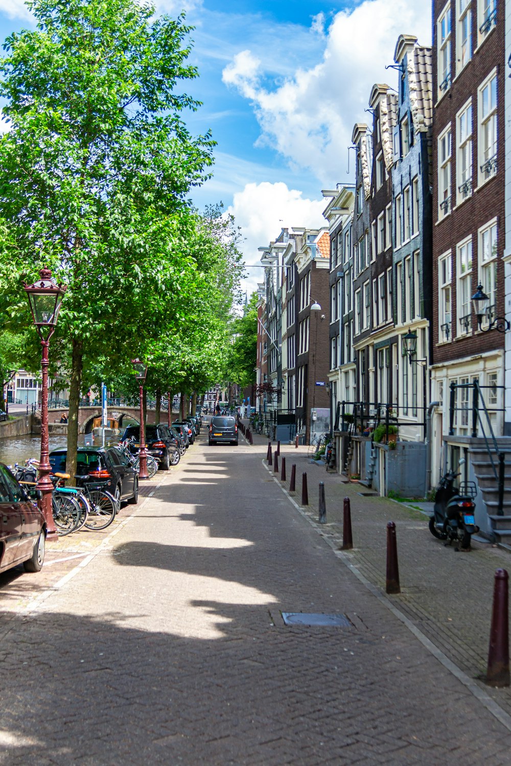 a street lined with parked cars and bicycles