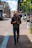 man holding black DSLR camera standing on sidewalk during daytime