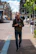 man holding black DSLR camera standing on sidewalk during daytime