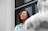 woman in blue and teal to by glass window