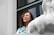 woman in blue and teal to by glass window