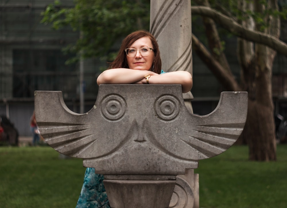 woman sitting on concrete owl seat