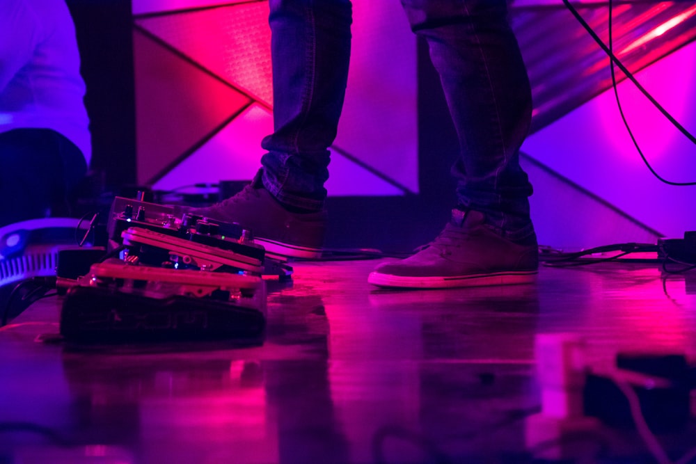 person performing on stage using guitar effects