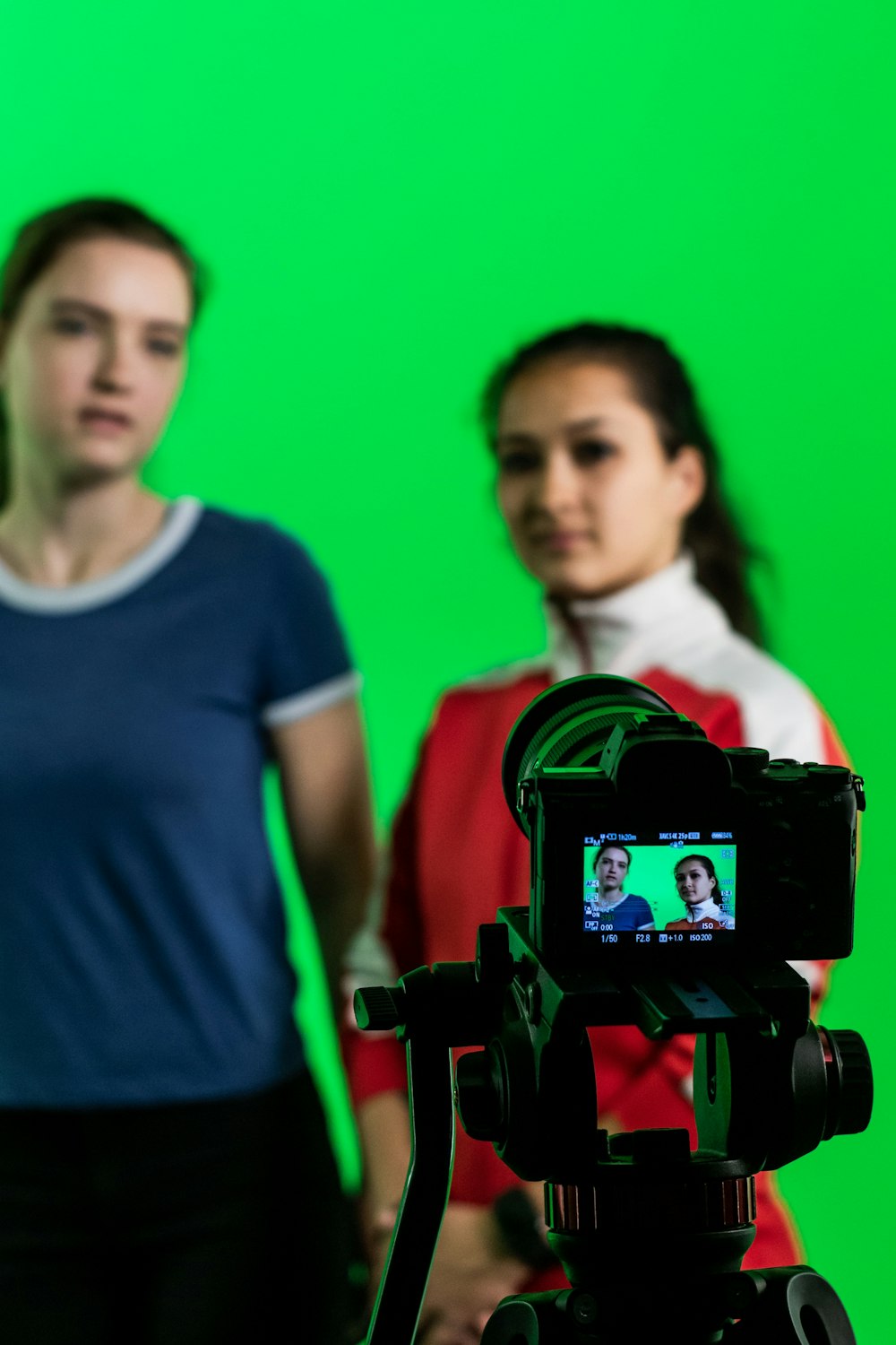 women standing near green wall