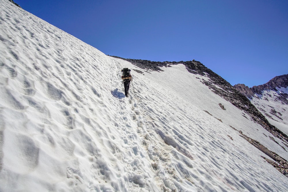 person hiking snow-covered mountain