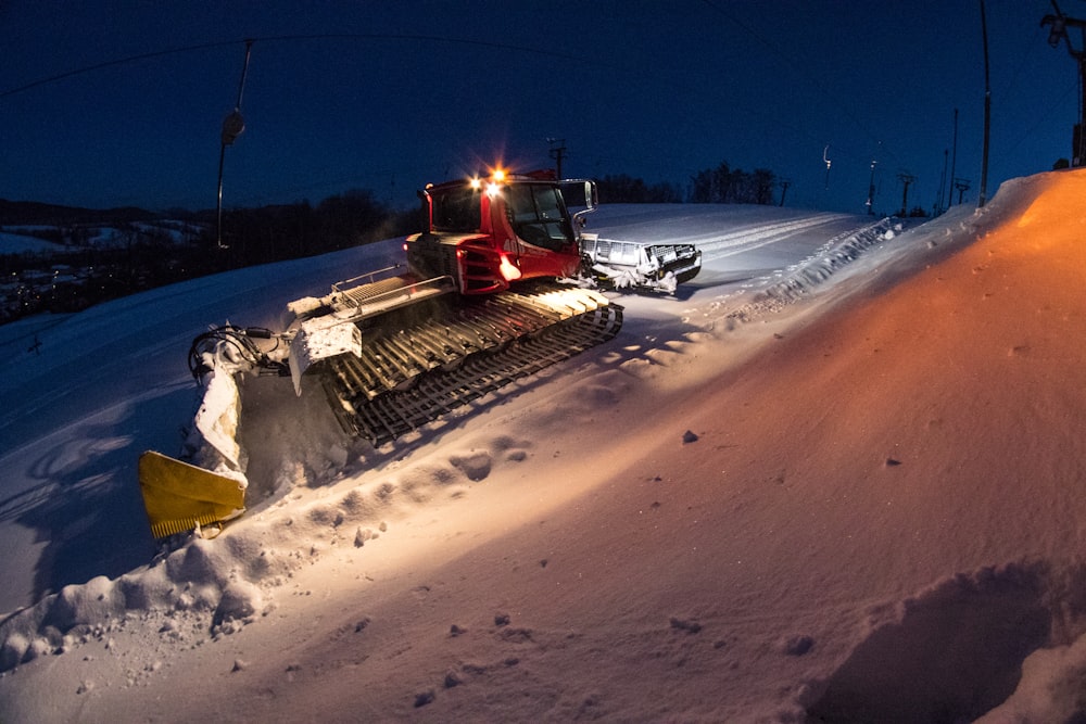 a snow plow sitting on top of a snow covered slope