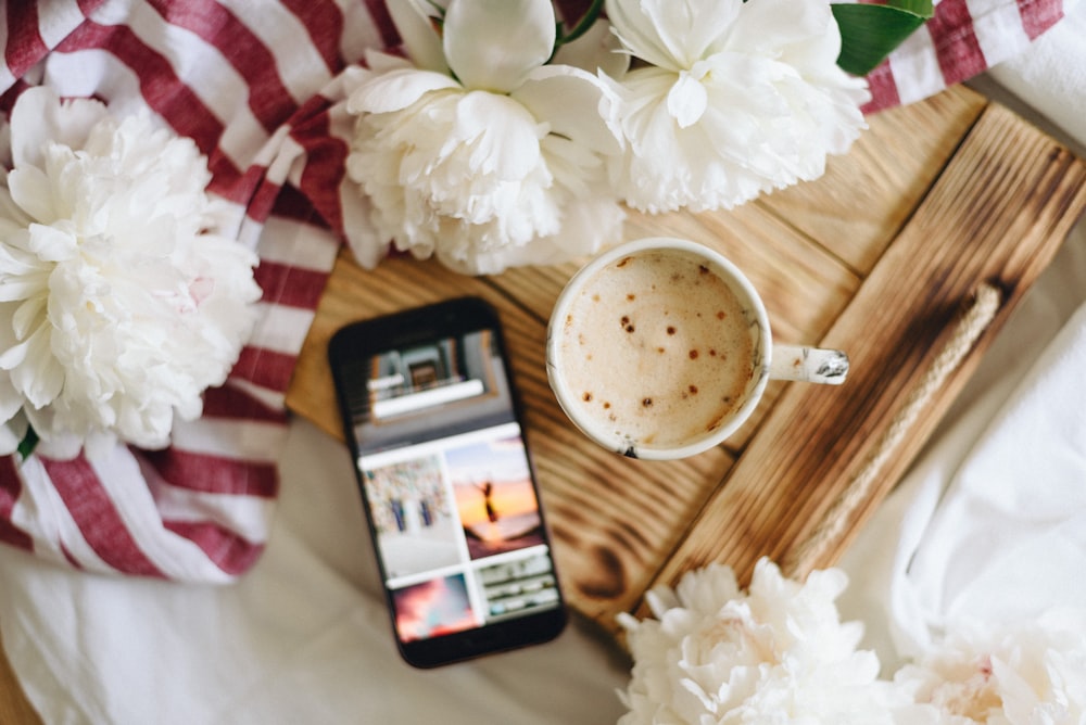 flat lay photography of mug of drink and black Android smartphone