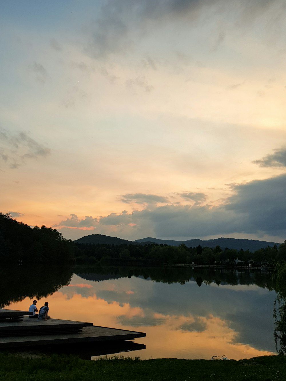 people seated on dock during golden hour