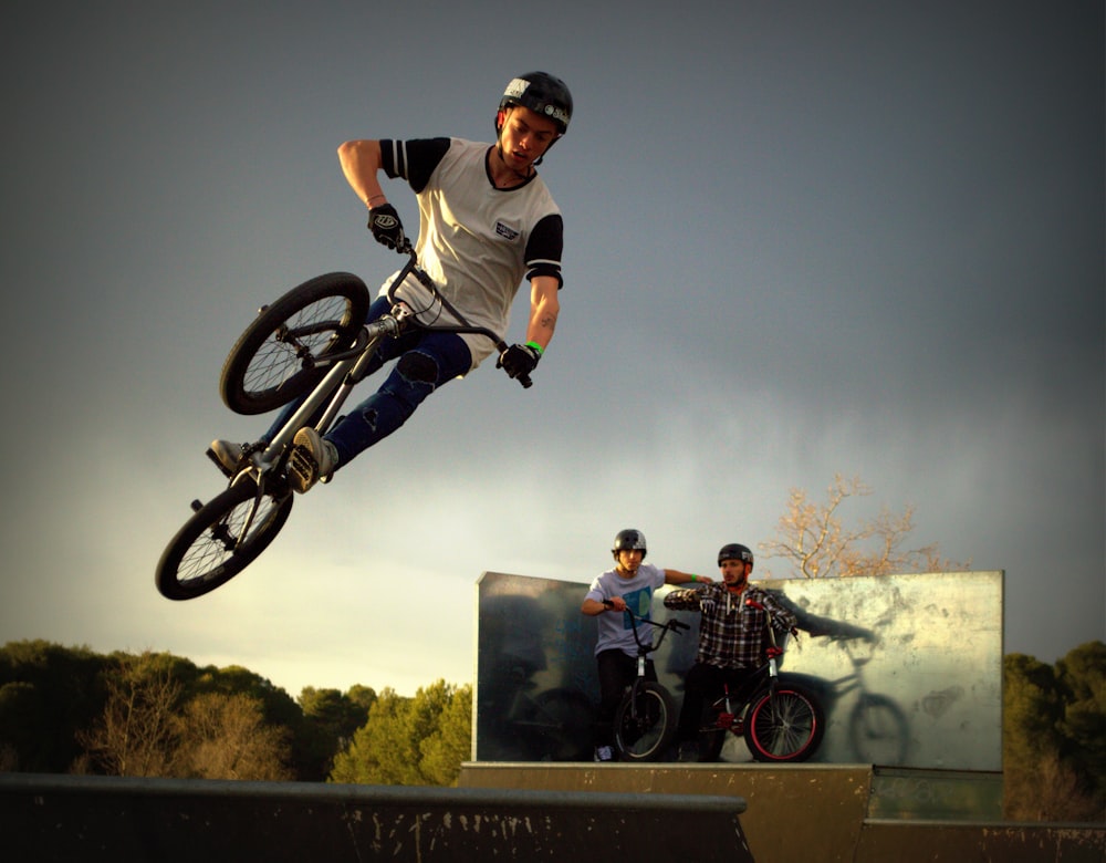 man riding black BMW mid air trick