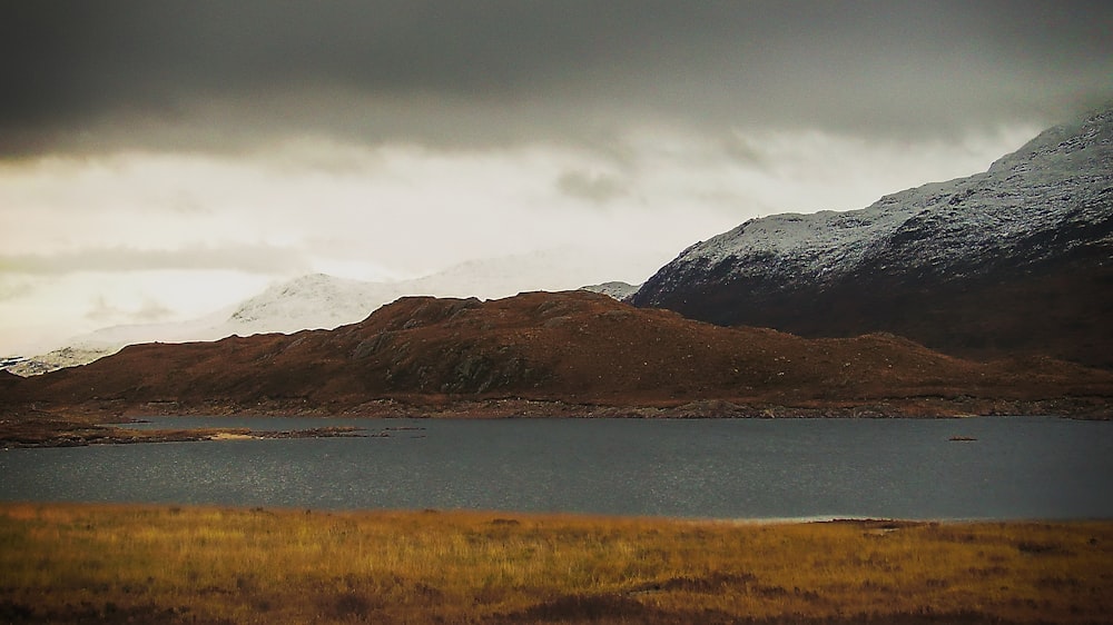 body of water brown mountains