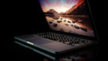 A sleek ultrabook open with a scenic wallpaper on the screen.