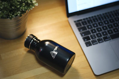 A sleek stainless steel water bottle with a secure lid on a wooden table.