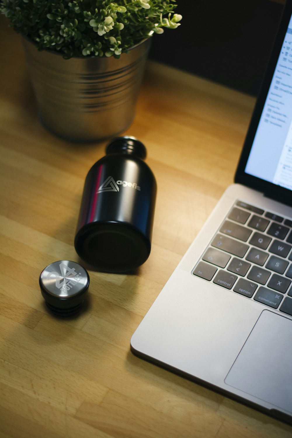 black bottle beside MacBook