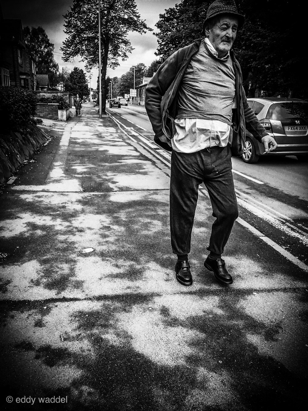 grayscale photography of man walking beside street