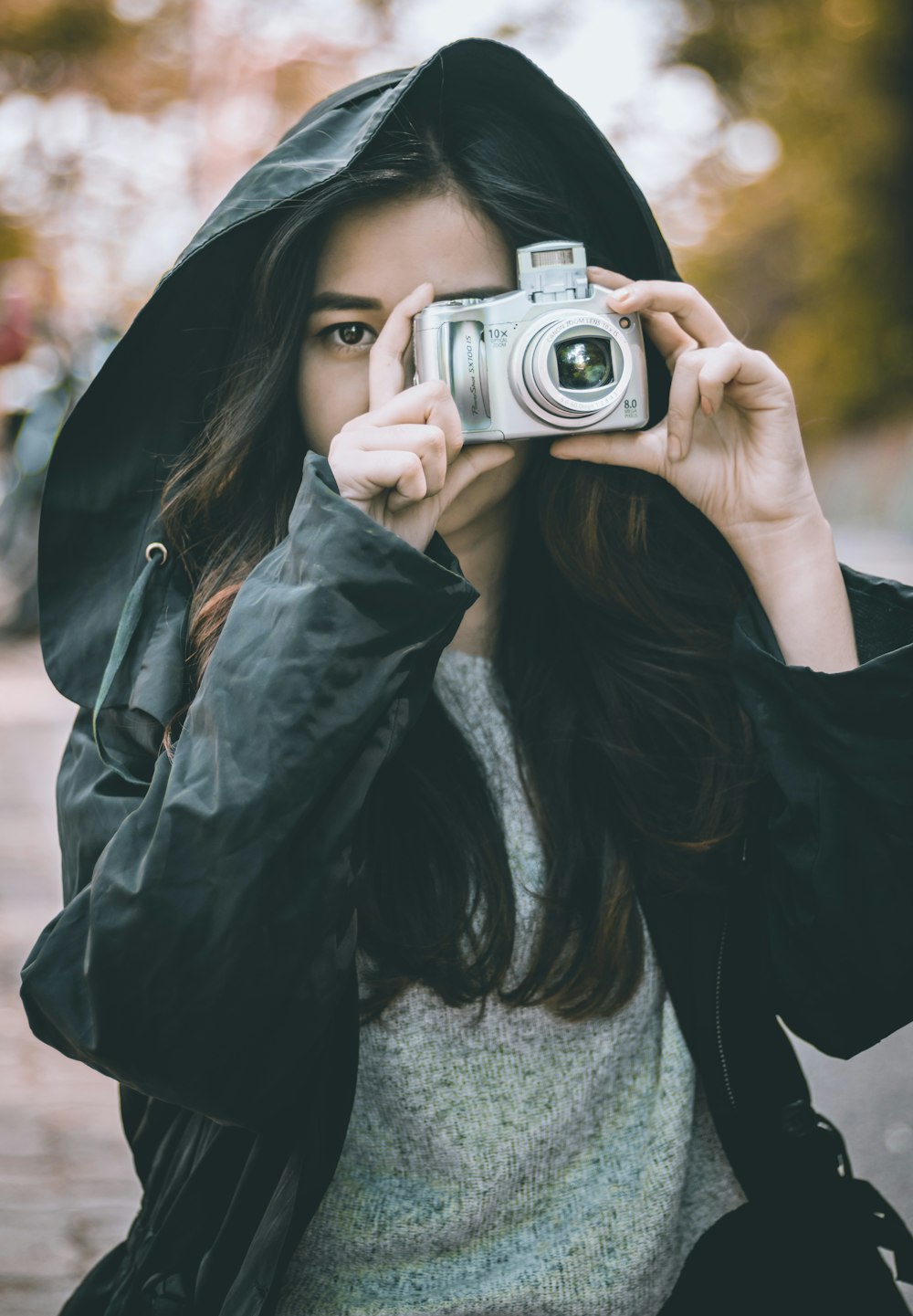 woman wearing jacket holding camera