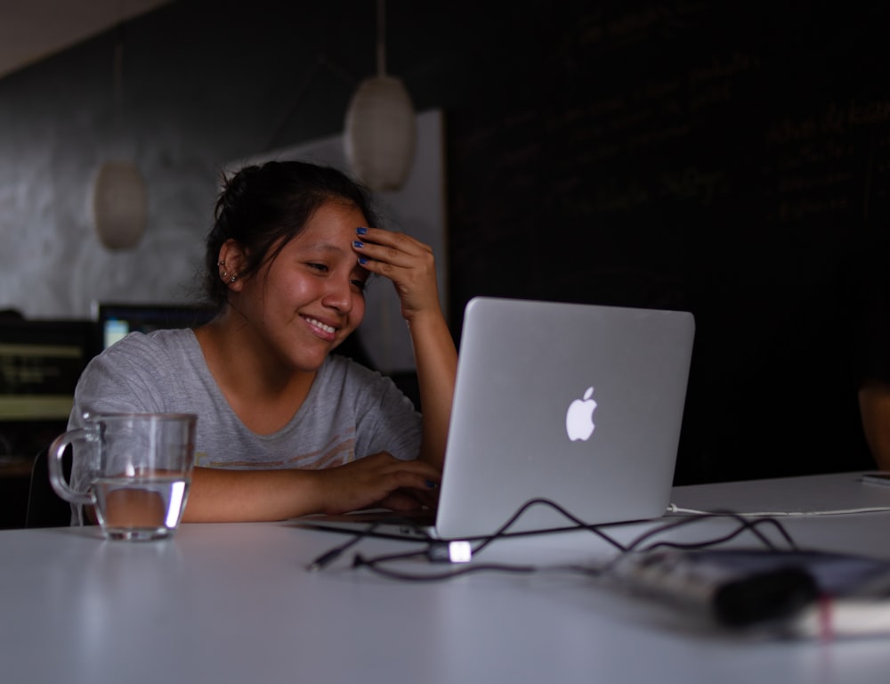 mulher sorridente usando MacBook