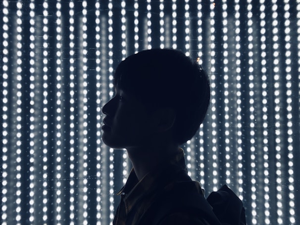 Artist silhouette framed against glowing LED panels during an intense performance moment.