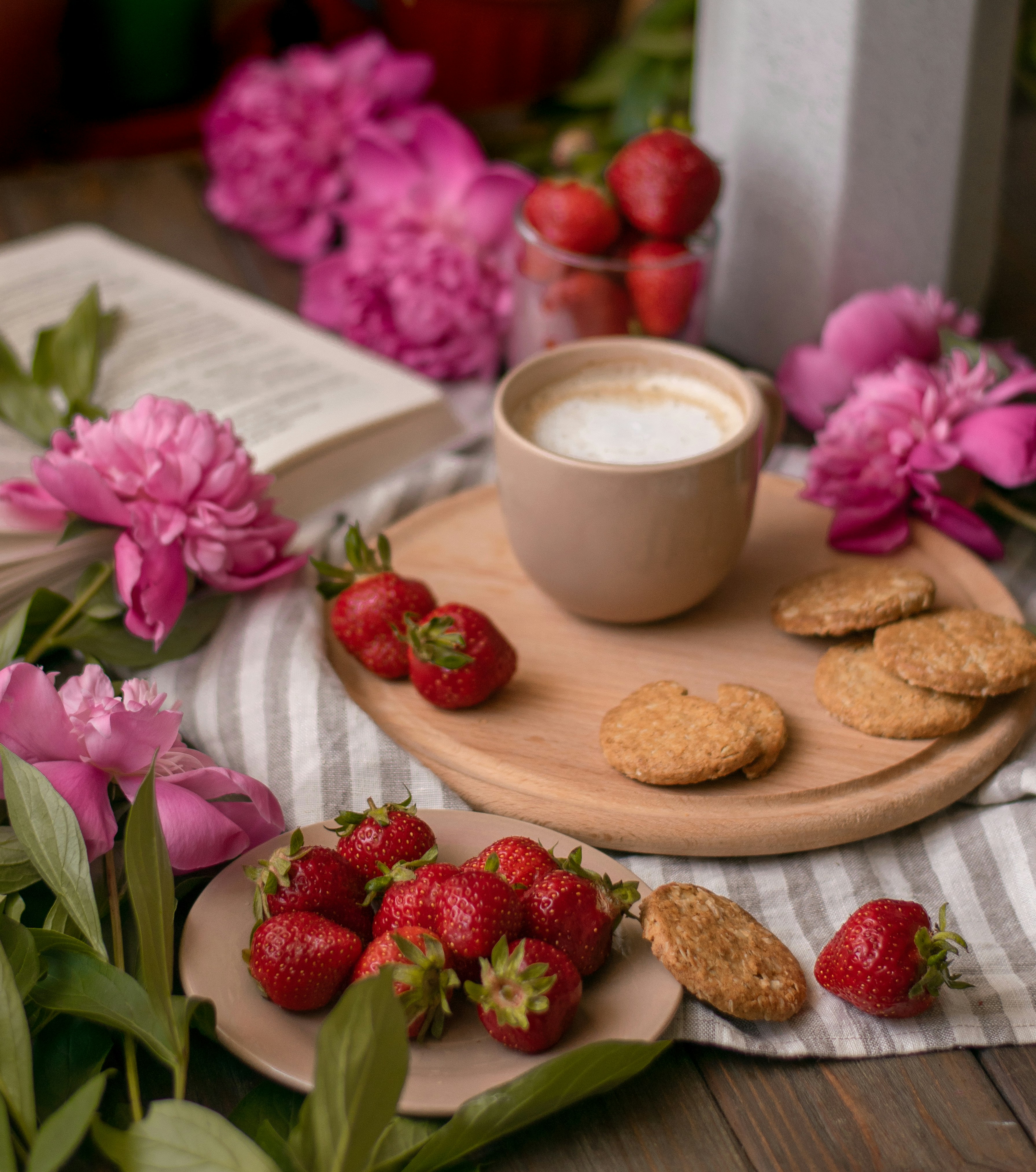 ceramic teacup with latte beside biscuits