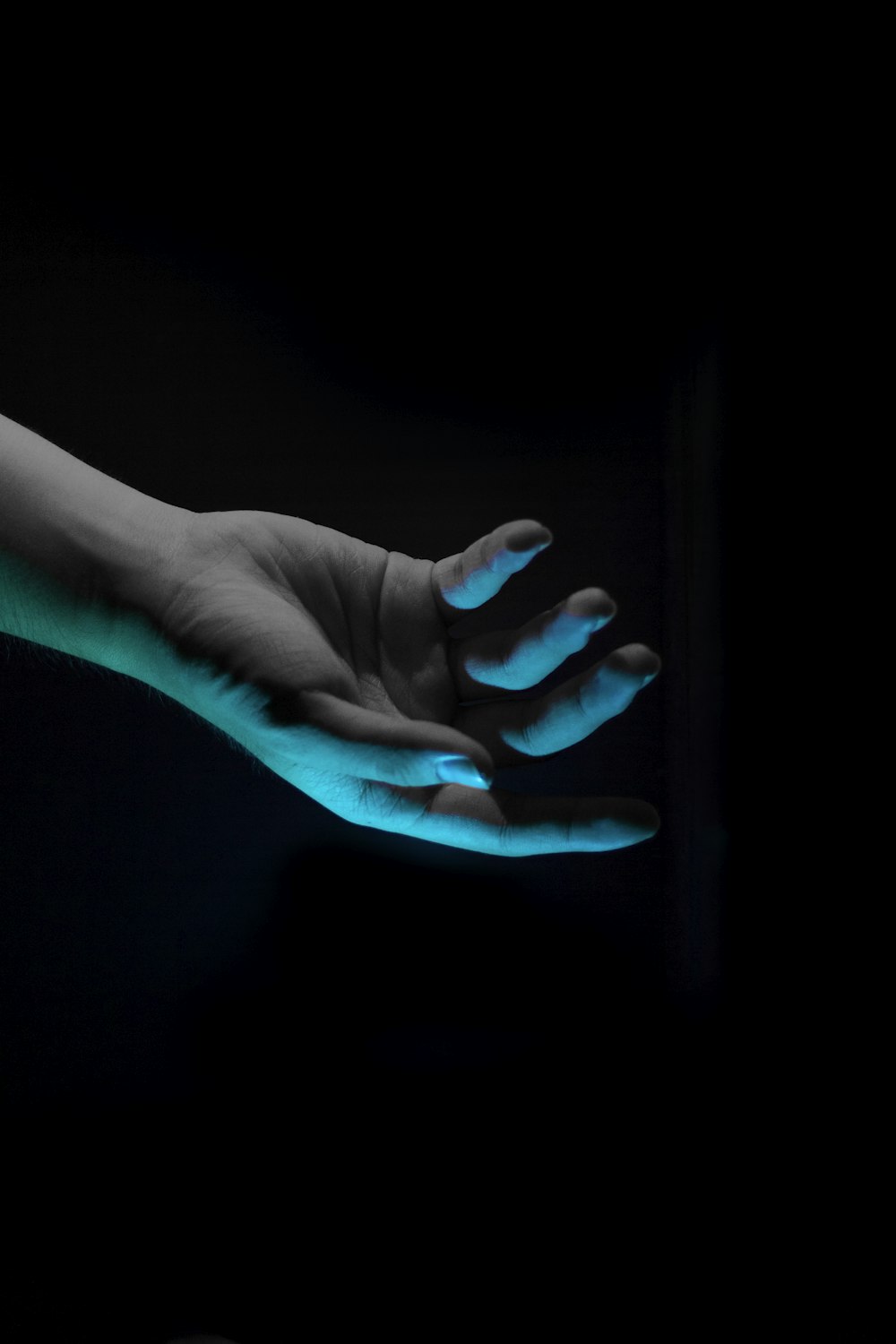 rechte menschliche Hand über blauem Licht